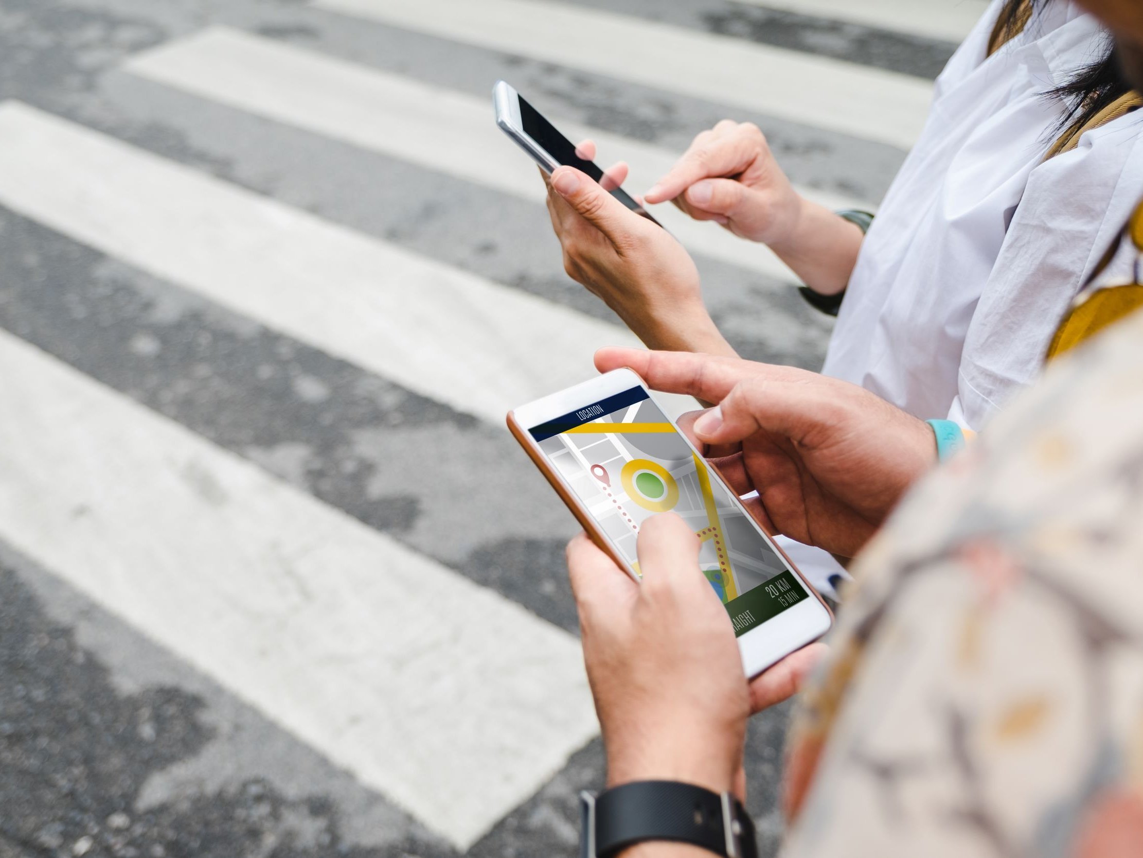 To personer ved fodgængerfelt holder telefoner med gps. Colourbox, #weedezign.