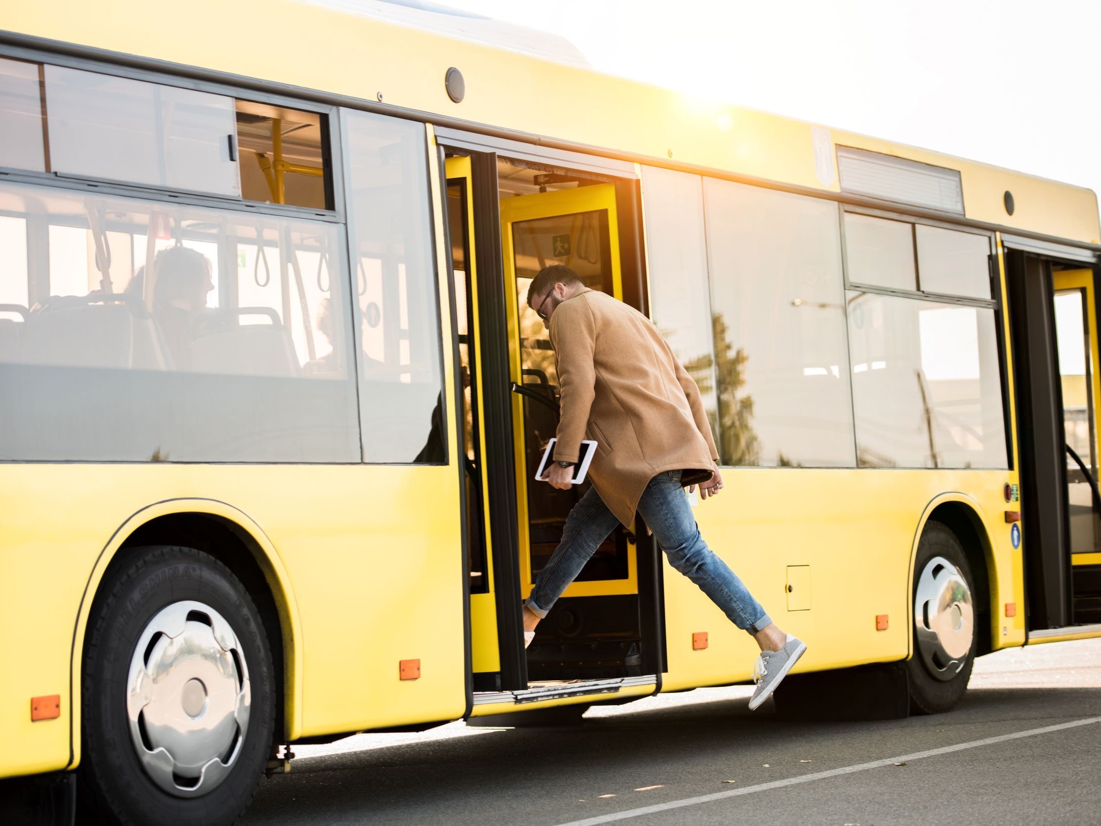 Person hopper med tablet hopper ind i bus. Colourbox, #246329.